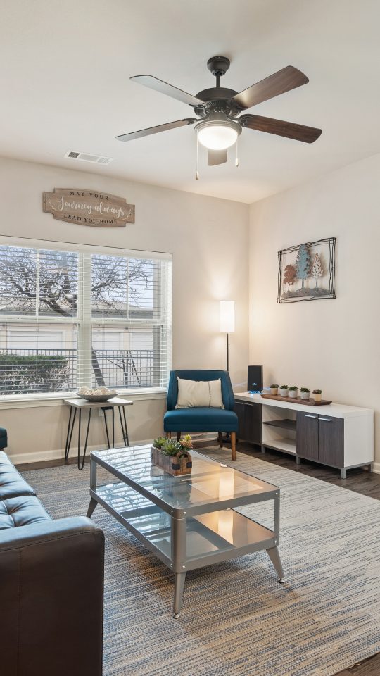 a living room with a ceiling fan and hardwood floors at The Creekside at Kenneys Fort