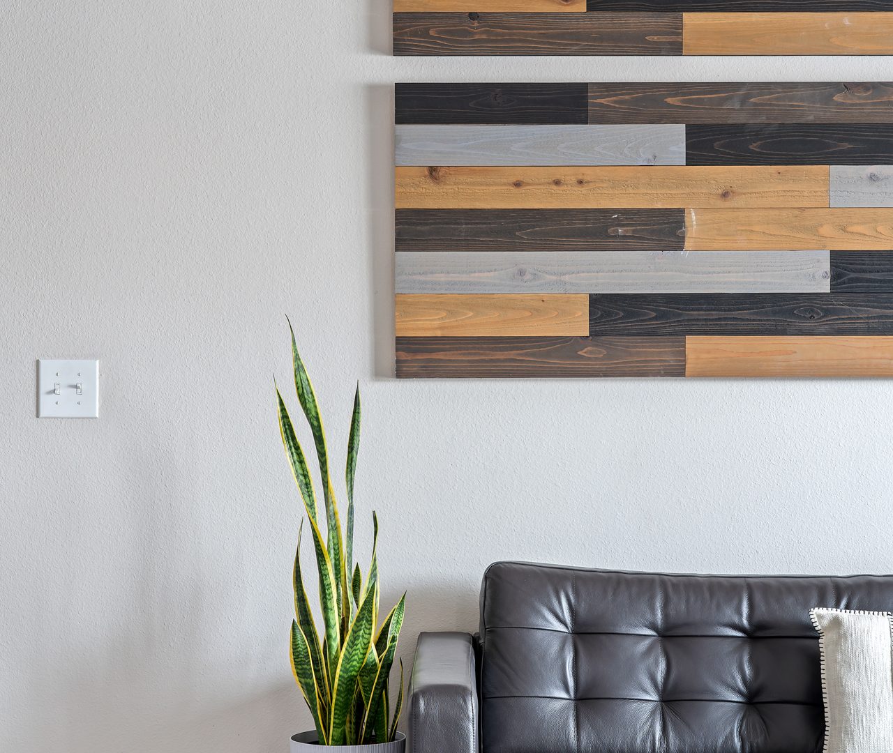 a living room with a couch and a wooden wall at The Creekside at Kenneys Fort